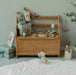 Maileg baby mouse on a tiny sledge in a festive room scene with gifts on a bench