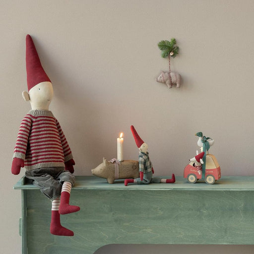 Maileg Little Sister mouse in her red car on a festive shelf with a pixie and candle
