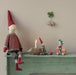 Maileg Little Sister mouse in her red car on a festive shelf with a pixie and candle