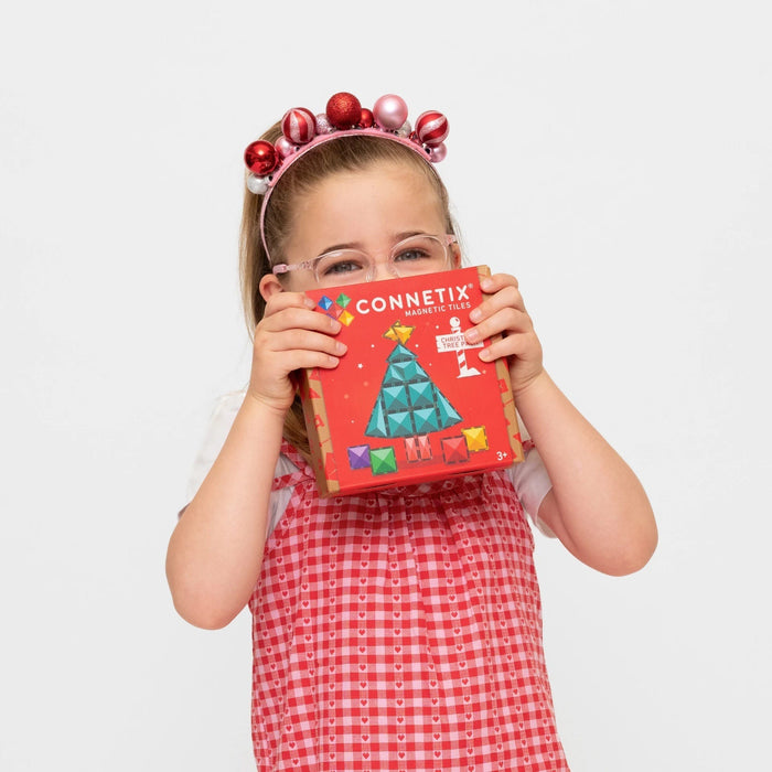 Girl holding the Connetix Christmas Tree Pack box