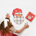 Child building a Santa face from red, peach and clear Connetix tiles