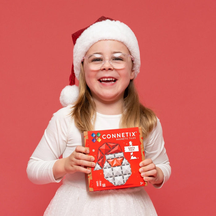 Girl in a Santa hat smiling with the Connetix Christmas Santa Pack