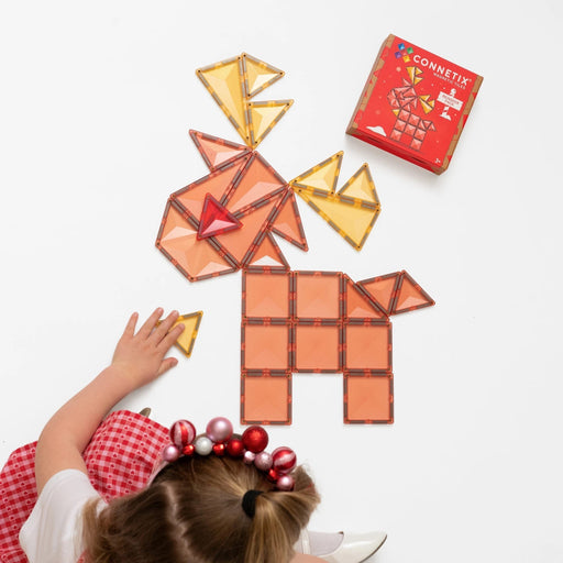 Child building a reindeer from pastel Connetix magnetic tiles beside the pack